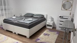 a bedroom with a bed with a mirror and a chair at Apartman Mešanović in Tuzla