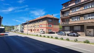 a city street with cars parked in front of buildings at Apartman Mešanović in Tuzla