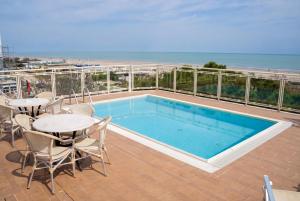 a swimming pool on a balcony with a table and chairs at Hotel Ariella in Milano Marittima +80 photos