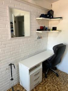 a white desk with a chair and a mirror at Suíte aconchego dos pássaros in Guaratuba +1 photo