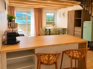 a kitchen with a counter with two chairs and a table at Hafenapartments Segelschule Mondsee in Mondsee
