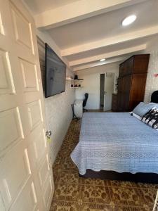 a bedroom with a bed and a white door at Suíte aconchego dos pássaros in Guaratuba