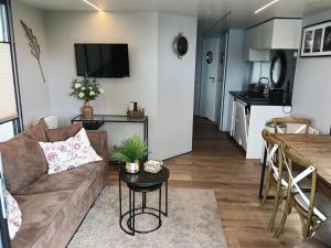 a living room with a couch and a table at Houseboat Enjoy with 200m Private Garden on the Lake in Vinkeveen +70 photos