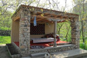 a stone shelter with a bed inside of it at Rahima's Guest House in Tadzhimi