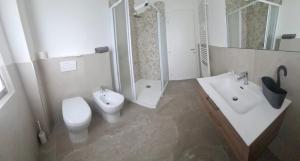 a white bathroom with a toilet and a sink at Casa Lilli in Zogno +14 photos