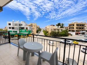 a balcony with a table and chairs and a view of a city at Valentino By ERMASS ex Valentinos Apts in Paphos