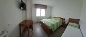 a bedroom with a bed and a desk and a television at Casa Lilli in Zogno