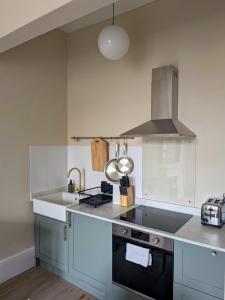 a kitchen with a sink and a stove at Modern Flat - Main St, Campbeltown in Campbeltown