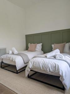 two beds sitting next to each other in a room at Modern Flat - Main St, Campbeltown in Campbeltown