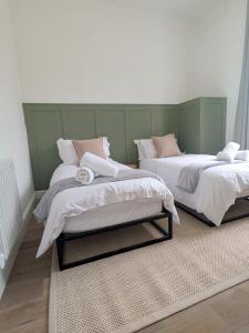 two beds sitting next to each other in a room at Modern Flat - Main St, Campbeltown in Campbeltown +27 photos