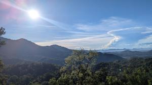 a view of a valley with the sun in the sky at Serenity peak cottage Ella in Badulla