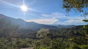a view of a valley with the sun in the sky at Serenity peak cottage Ella in Badulla