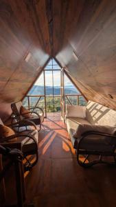 three beds in a room with a large window at Serenity peak cottage Ella in Badulla