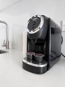 a coffee maker on a kitchen counter with two cups at Valentino By ERMASS ex Valentinos Apts in Paphos