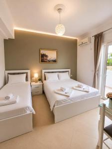 a bedroom with two beds and a window at Villa Kreshta in Ksamil