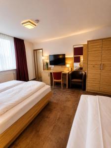 a hotel room with a bed and a desk at Hotel Pale Wolfsburg 24H Self Check-in in Wolfsburg
