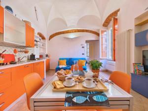 a kitchen with orange cabinets and a table with food on it at Rivierarent Casa Nemo in Finale Ligure