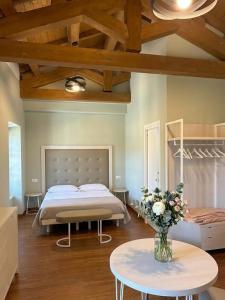 a bedroom with a bed and a table with a vase of flowers at Hotel Ristorante Fontana in Calestano