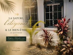 a sign on the side of a building with plants at Hotel El Elyon Ti Extra in Terrier Rouge