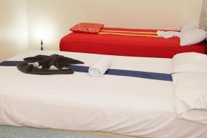two beds in a room with white and red at Hotel El Elyon Ti Extra in Terrier Rouge