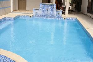 a large blue pool with two blue chairs in it at Hotel El Elyon Ti Extra in Terrier Rouge