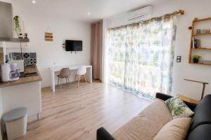 a living room with a couch and a large window at Studio la garrigue in Les-Pennes-Mirabeau