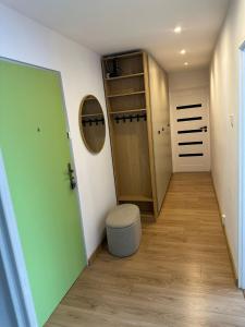 a hallway with a green door and a stool at Apartament Blue Velvet in Skierniewice