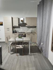 a kitchen with a table and chairs in a room at CAMARDA HOME in Bernalda