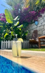 a glass of lemonade sitting on a table next to a pool at Windmill Alaçatı in Alaçatı +152 photos