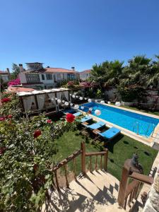 a swimming pool with tables and chairs next to at Windmill Alaçatı in Alaçatı
