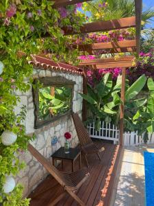 a wooden deck with a chair and a table at Windmill Alaçatı in Alaçatı
