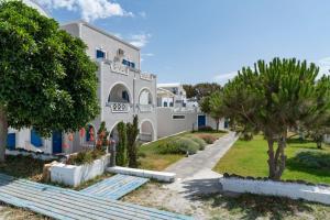 a building with stairs and trees in front of it at Studio in a family hotel in Perivolos