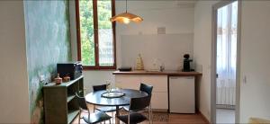 a kitchen with a table and chairs in a room at L escapade de la voie douce in Le Cheylard