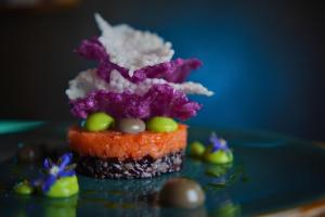a carrotcake with purple flowers on top of it at Hotel Stüa Granda in Soglio +52 photos