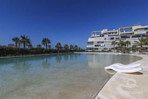 a swimming pool in front of a building with palm trees at Ocean Homes, Vista Mar y piscina EXCELLENT & SOLMARES in Punta del Caimán