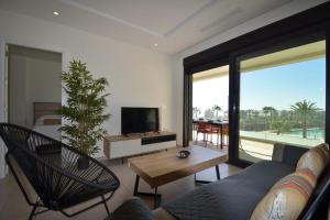 a living room with a couch and a tv at Ocean Homes, Vista Mar y piscina EXCELLENT & SOLMARES in Punta del Caimán