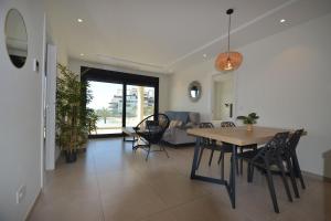 a dining room and living room with a table and chairs at Ocean Homes, Vista Mar y piscina EXCELLENT & SOLMARES in Punta del Caimán