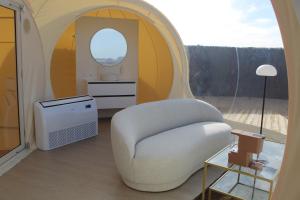 a living room with a white chair and a window at Wine Bubble in Cuzcurrita-Río Tirón