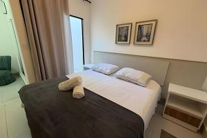 a bedroom with a bed with two towels on it at Aconchegante Apartamento com Ar Condicionado in Araxá