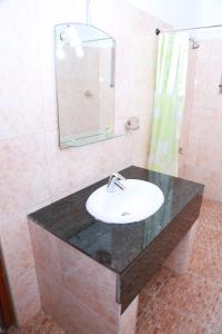 a bathroom with a sink and a mirror at Sumal Villa in Beruwala
