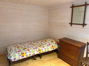 a small room with a bed and a dresser at Chez Emile in Chavornay