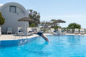 a man is in the water in a swimming pool at Studio in a family hotel in Perivolos