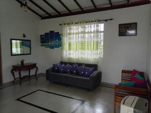 a living room with a couch and a table at The Sun Horse Villa in Unawatuna