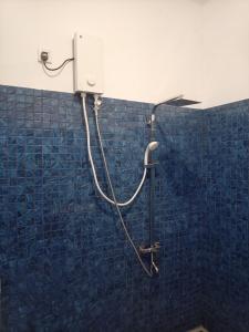 a shower in a bathroom with a blue tiled wall at The Sun Horse Villa in Unawatuna +41 photos