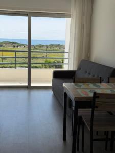 a living room with a couch and a table and a large window at AFIFE T1D Bouça Cabrita Residences in Afife