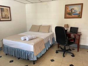 a bedroom with a bed and a desk and a computer at El Callejon Guest House in León