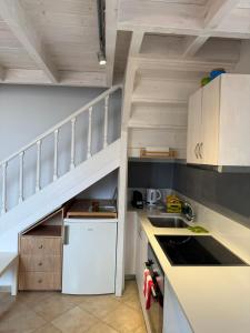 a kitchen with a white refrigerator and a staircase at Amalia Harbor in Halki