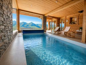 an infinity pool in a house with a mountain view at La Framboiseille - Chalet de Luxe avec Piscine Intérieure et Sauna - Vue Montagne in Manigod