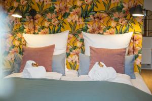 a bedroom with a bed with pillows and a floral wall at Design Mini Studio No 9, Küche, Parkplatz, Wifi by BALANCED in Holzkirchen