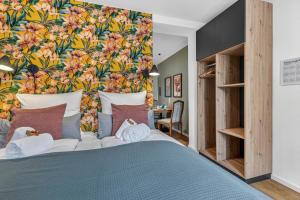a bedroom with a bed with a floral wall at Design Mini Studio No 9, Küche, Parkplatz, Wifi by BALANCED in Holzkirchen +17 photos